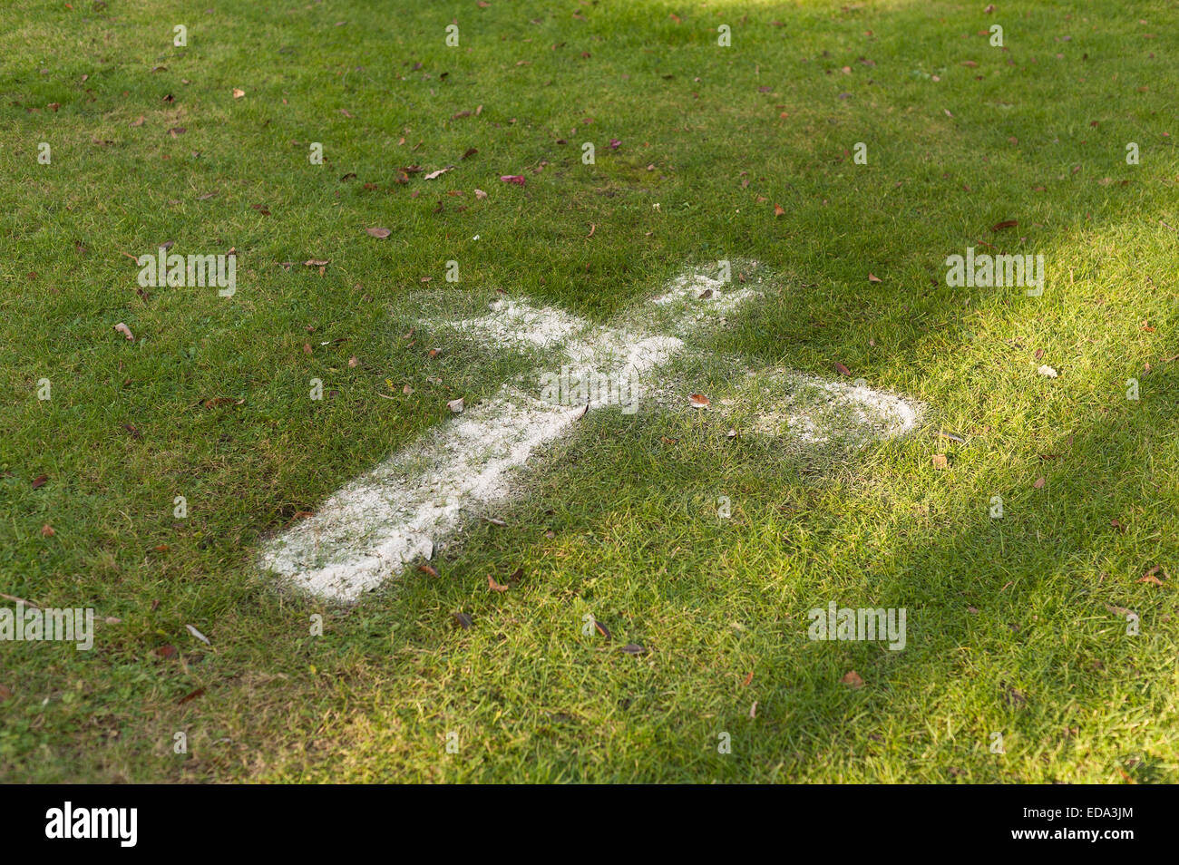 Physical remains of a precious loved one made out in the shape of a cross in a scattering of ashes in a crematorium Stock Photo