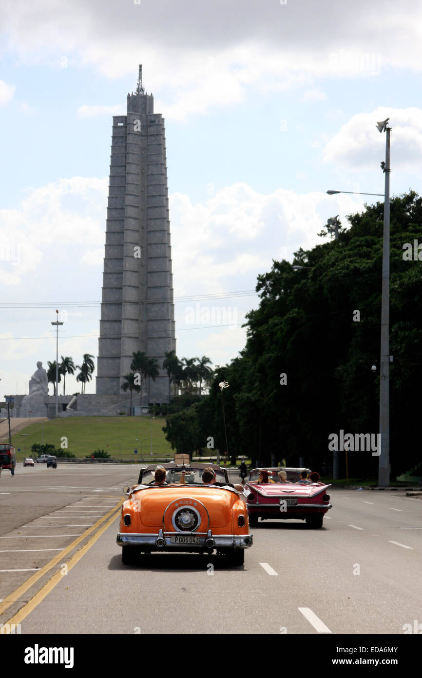 Classic vintage American cars driving in front of the José Martí Memorial in Place de la Revolucion Stock Photo