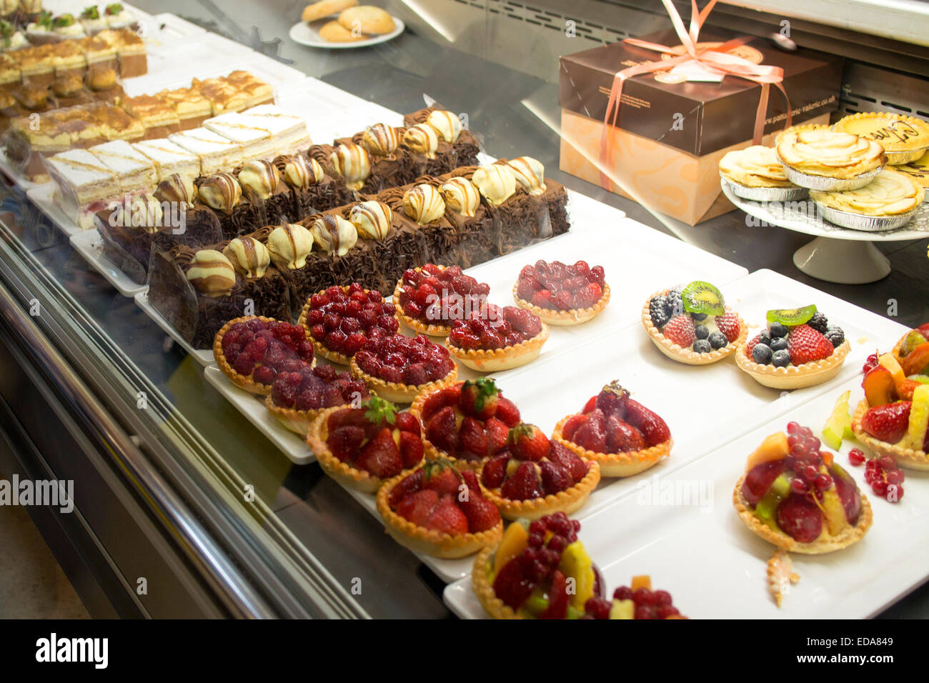 A selection of valerie patisserie individual portions slices cakes in a shop counter Stock Photo