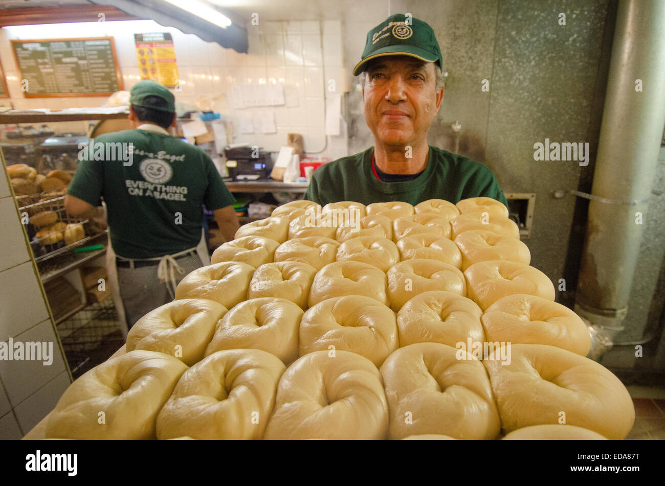 Kettle-boiled bagels are transported to the oven for its final stage of preparation at New York City's Ess-a-Bagel. Stock Photo