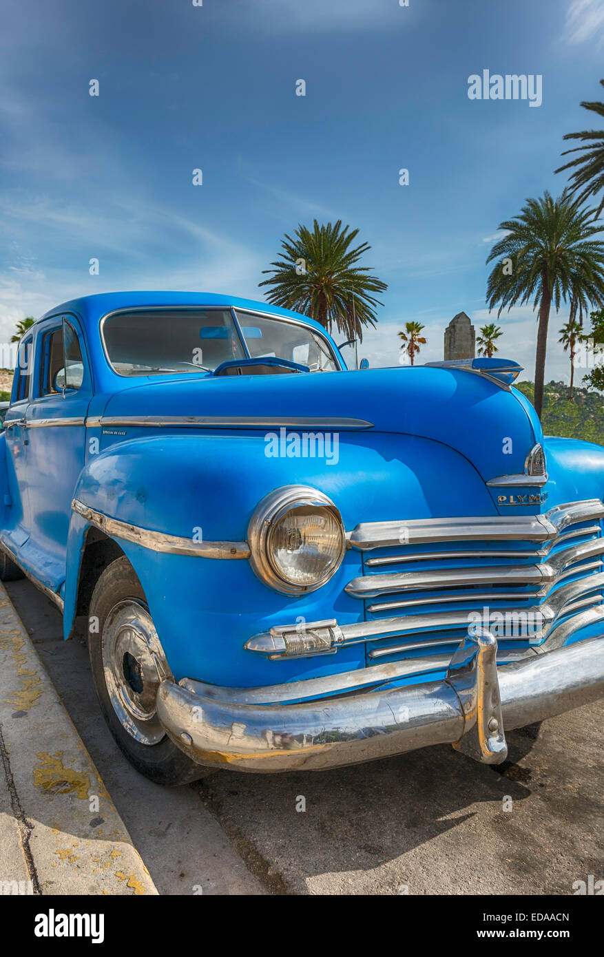 A low front shot of a bright blue antique car on the street in Cuba. Stock Photo
