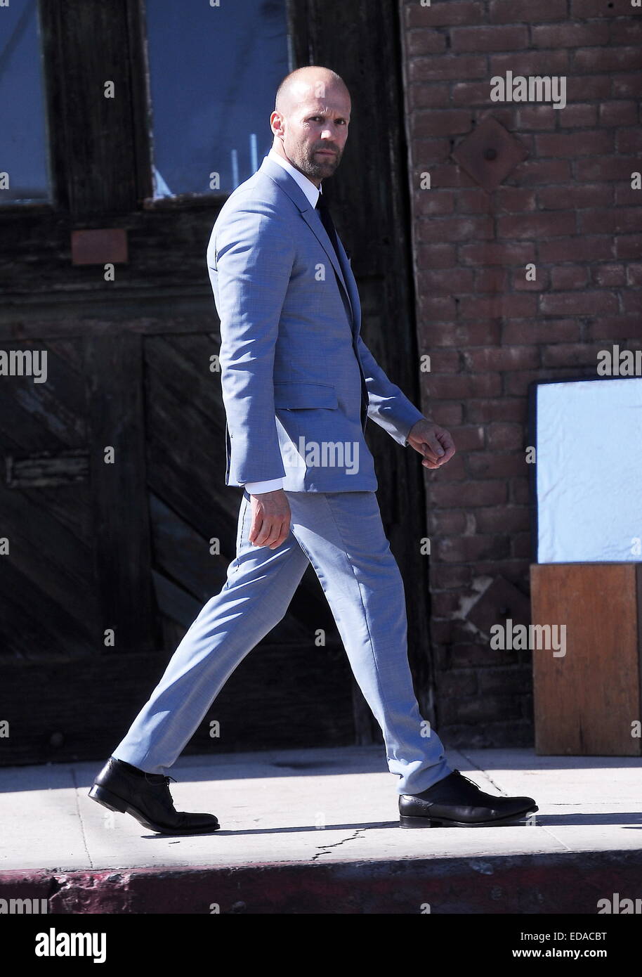 Actor Jason Statham puts on a gray suit at a photoshoot in