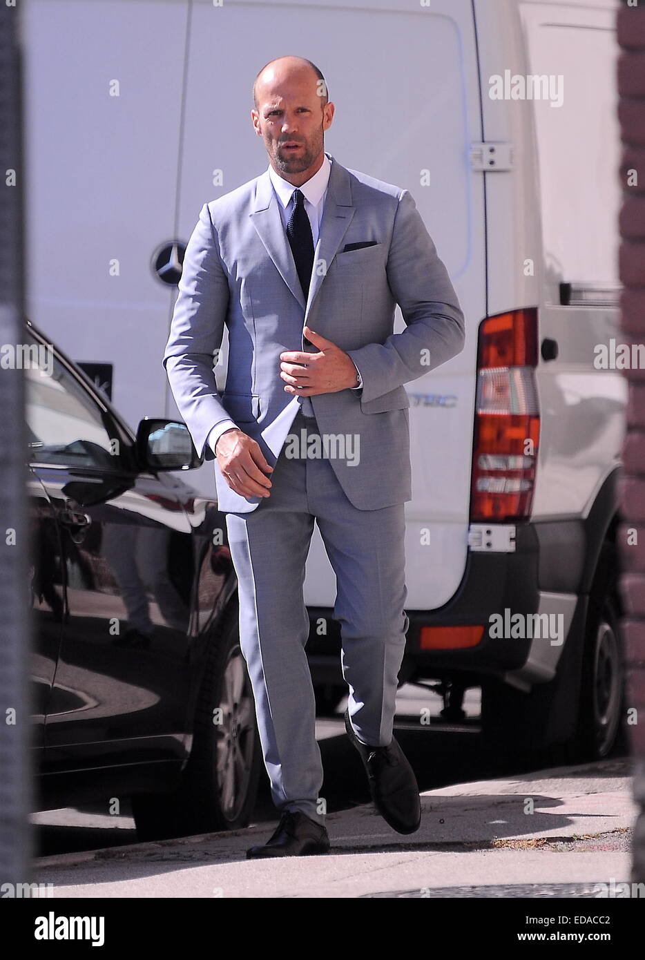 Actor Jason Statham puts on a gray suit at a photoshoot in downtown L.A for French GQ magazine with famous photgrapher Jeff Lipsky.  Featuring: Jason Statham Where: Los Angeles, California, United States When: 01 Jul 2014 Stock Photo