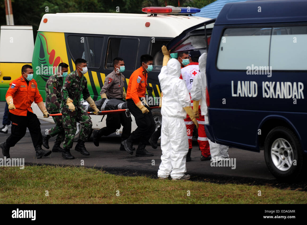 Pangkalan Bun, Indonesia. 4th Jan, 2015. Indonesian search and rescue members carry the body of a victim of AirAsia Flight QZ 8501 from MH-60R Seahawk helicopters in Pangkalan Bun, Indonesia, Jan. 4, 2015. An Indonesian pilot taking part in the multinational search operation said here on Sunday that three more bodies were found in AirAsia crash site off Borneo coast. Credit:  Agung Kuncahya B./Xinhua/Alamy Live News Stock Photo
