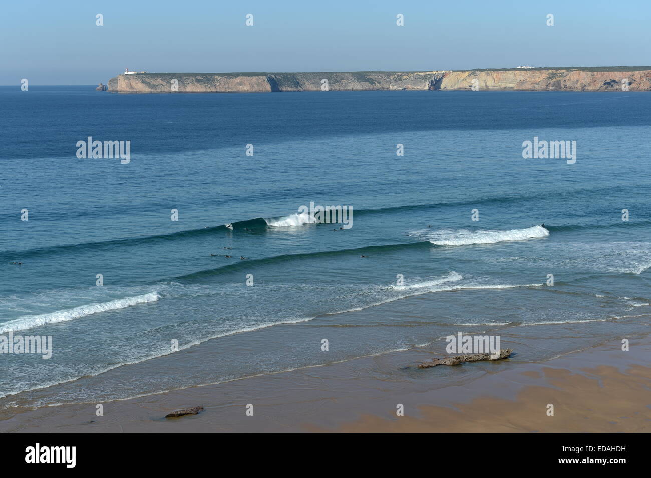 perfect waves at  Tonel Beach Sagres with Cape St. Vincent lighthouse in background Stock Photo