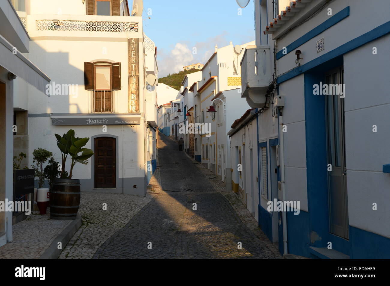A single figure on Rue de Pescadores, a narrow   cobbled road  in Salema  that has retained its original charm. Stock Photo