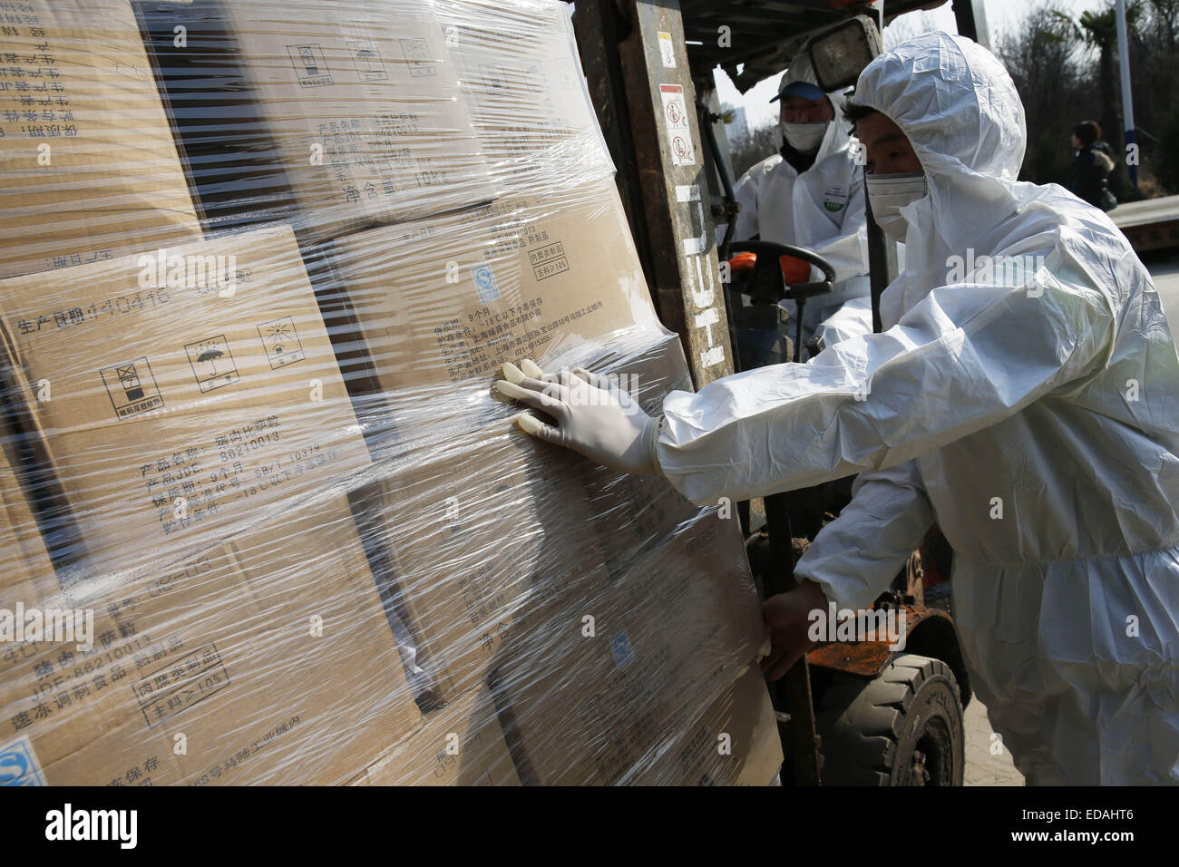 Shanghai, China. 4th Jan, 2015. Workers of an innocuous treatment center take Husi's unqualified food to dispose in Shanghai, east China, Jan. 4, 2015. A total of 521.21 tons of unqualified food Husi recalled were safely disposed after the last 1415 boxes were disposed on Sunday. Shanghai Husi Food Co., Ltd, a meat supplier for mainly McDonald and KFC, was investigated in July of 2014 for supplying stale meat to McDonald and KFC outlets. © Pei Xin/Xinhua/Alamy Live News Stock Photo