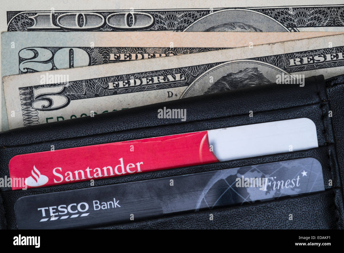 Wallet containing Santander and Tesco bank cards, and american dollars. Stock Photo