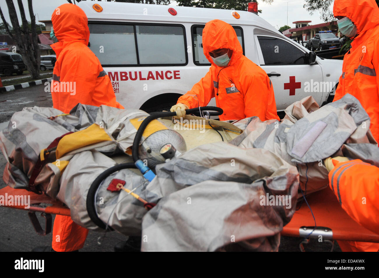 Pangkalan Bun, Indonesia. 4th Jan, 2015. Search and rescue personnel carry debris of the AirAsia flight QZ8501 from a Singapore Navy helicopter at Iskandar Air Base, Pangkalan Bun, Indonesia, Jan. 4, 2015.? Credit:  Veri Sanovri/Xinhua/Alamy Live News Stock Photo