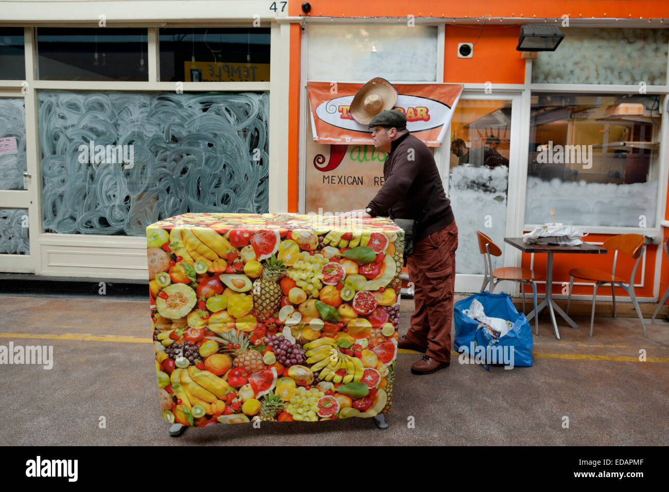 Shop Owner Clearing up on a quiet Sunday in Brixton Village, London Stock Photo