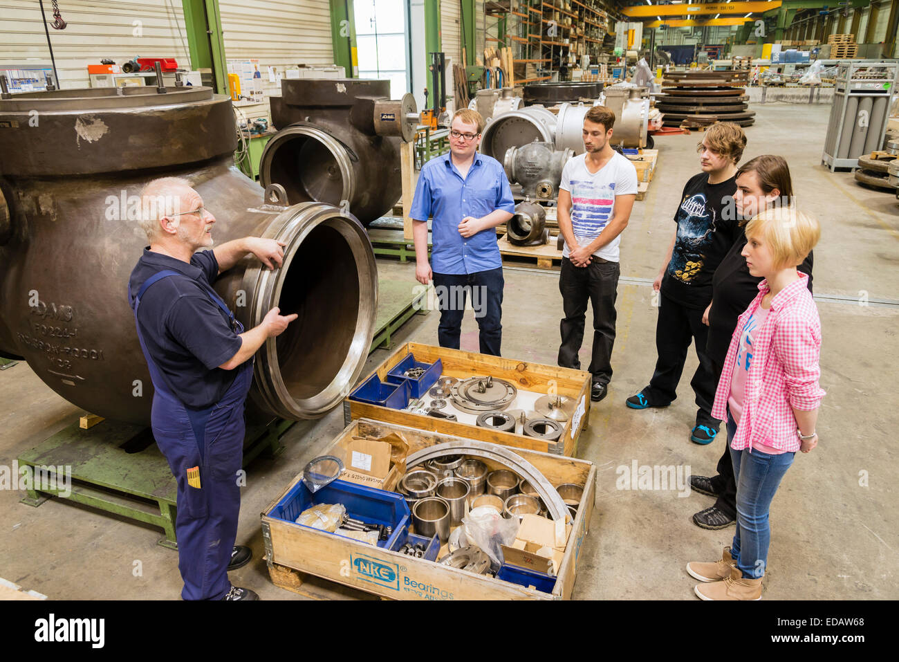 A trainee teacher, left, shows a production hall to new apprentices at the start of their apprenticeship. Stock Photo