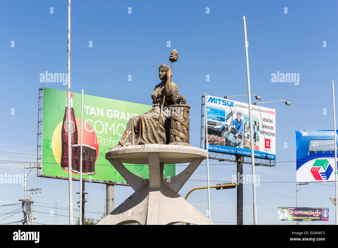 Roadside statue of a seated woman in Arequipa at the beginning of the Colca Canyon, Peru, in the middle of the road in front of advertising billboards Stock Photo