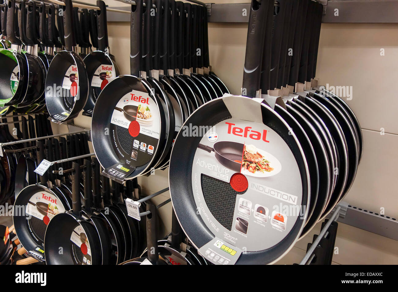 different sizes of Tefal red spot non stick frying pans hanging on display  and for sale in UK Tesco supermarket Stock Photo - Alamy