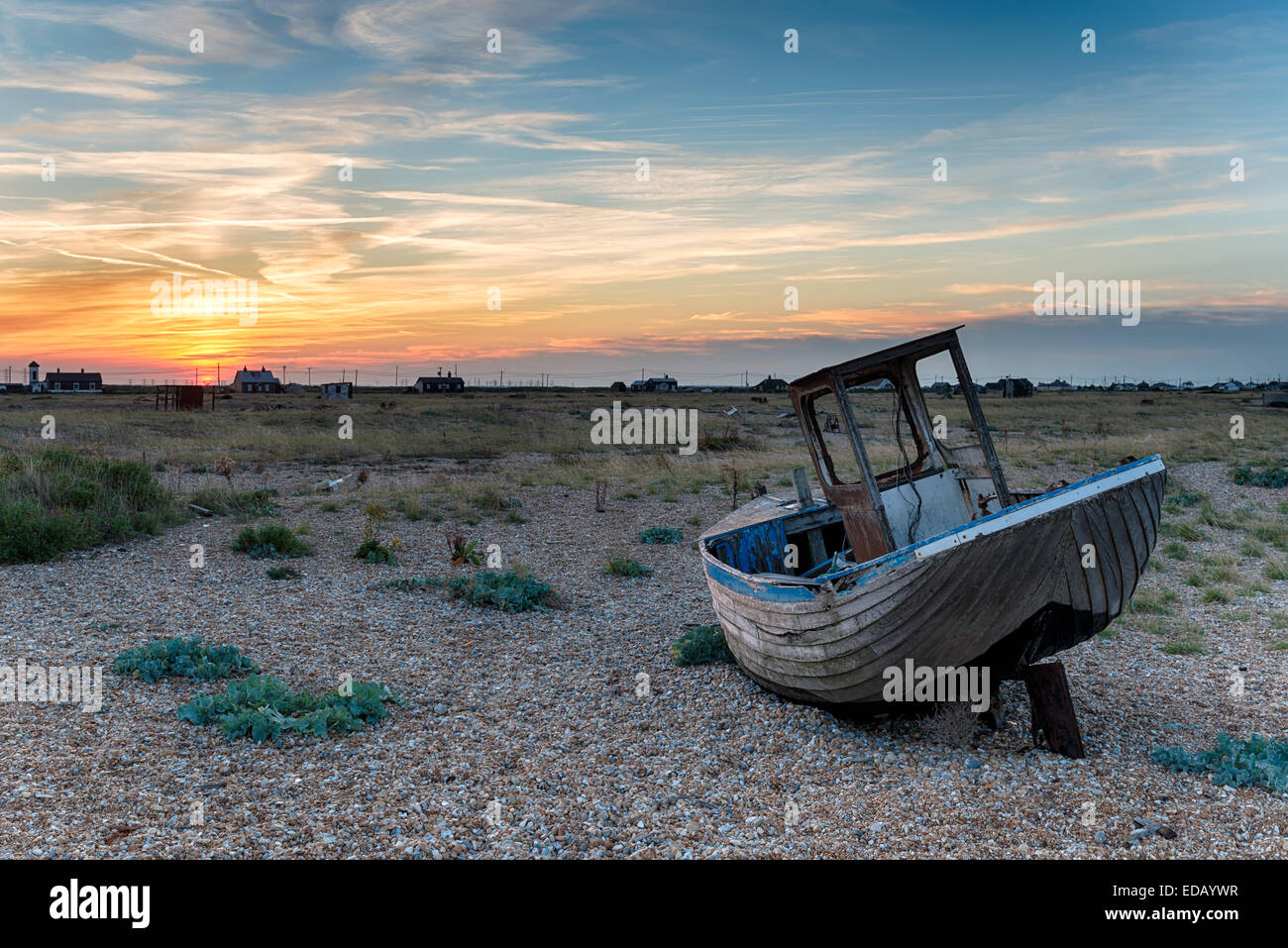 An old wooden fishing boat stranded on shingle in Kent under a dramatic ...
