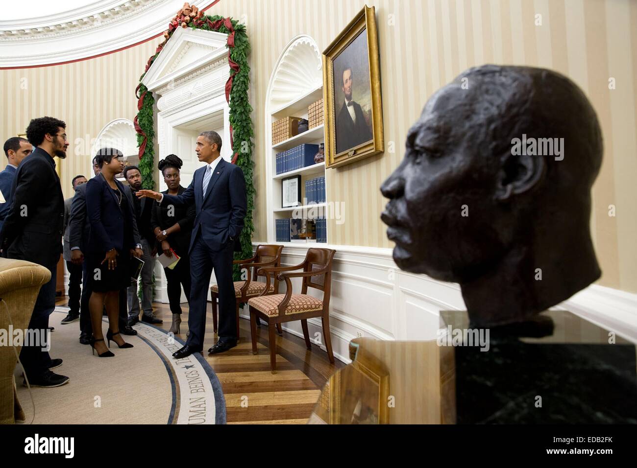 US President Barack Obama with young civil rights leaders in the wake of the Michael Brown shooting by a policeman, during a meeting in the Oval Office of the White House December 1, 2014 in Washington, DC.  Dec. 1, 2014 'Following the outcry over the shooting of Michael Brown by a policeman in Ferguson, Missouri, the President invited to a meeting in the Oval Office. Many of them had protested in Ferguson. A 30-minute scheduled meeting lasted more than an hour. As the meeting broke up, the President continued the conversation for a few minutes. Stock Photo