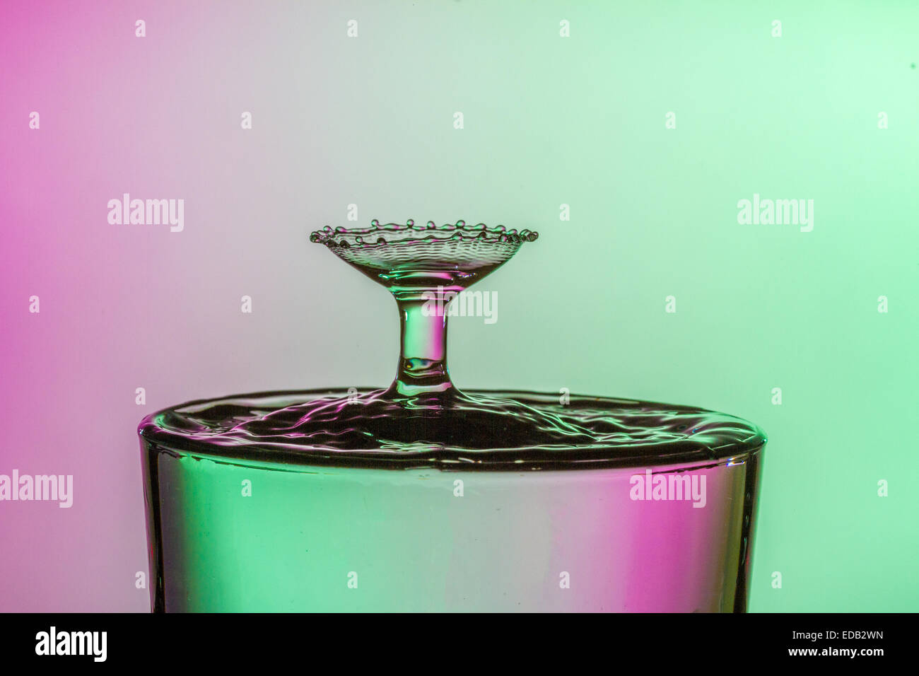 Water drop collision into a glass of water. Water droplets splashing ...