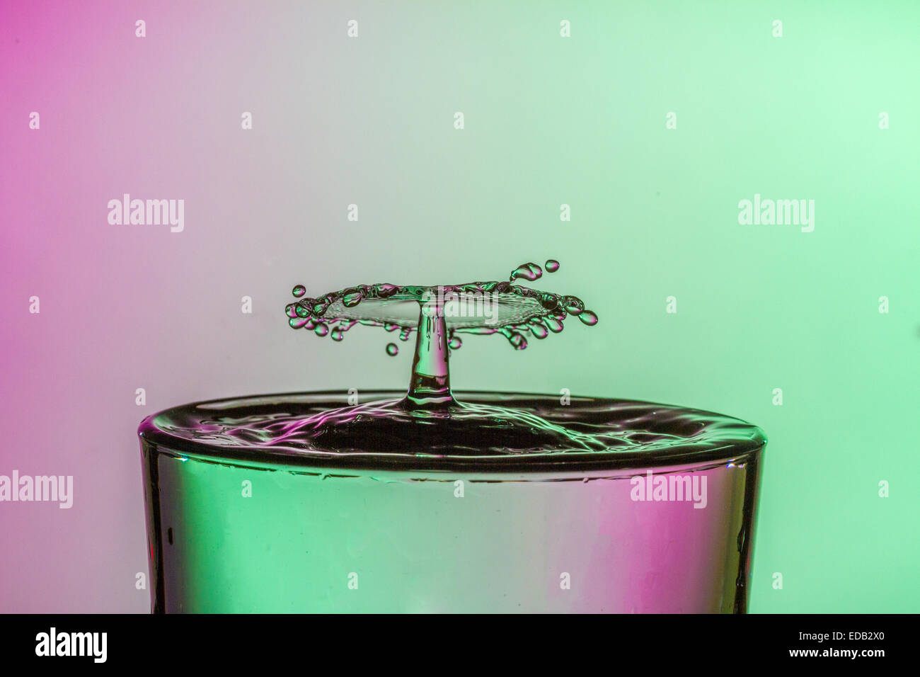 Water drop collision into a glass of water. Water droplets splashing ...