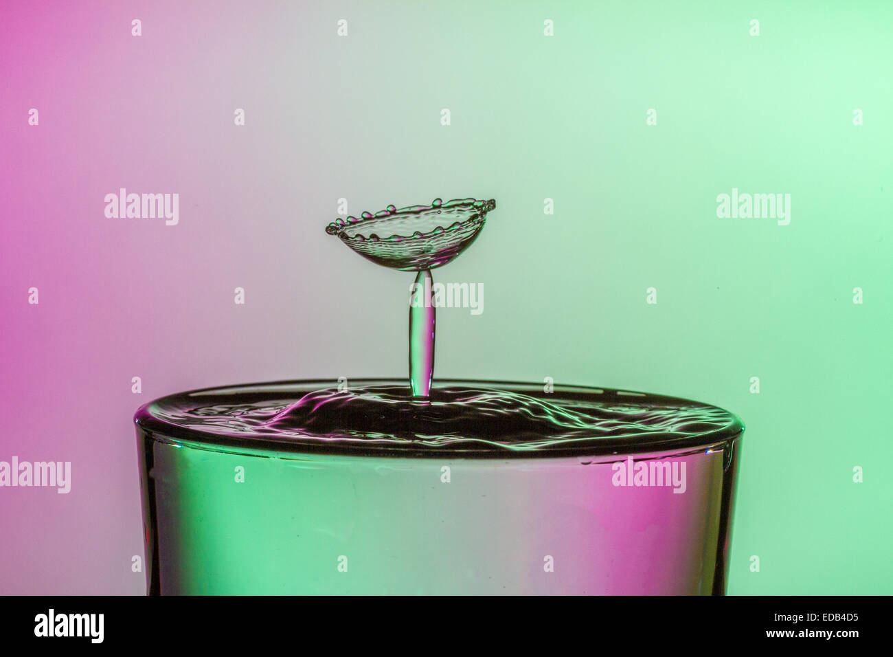 Water drop collision into a glass of water. Water droplets splashing ...