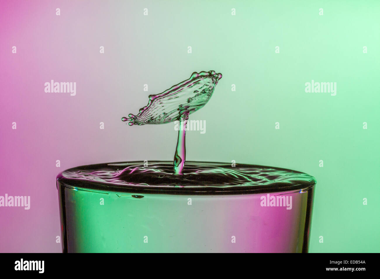 Water drop collision into a glass of water. Water droplets splashing ...