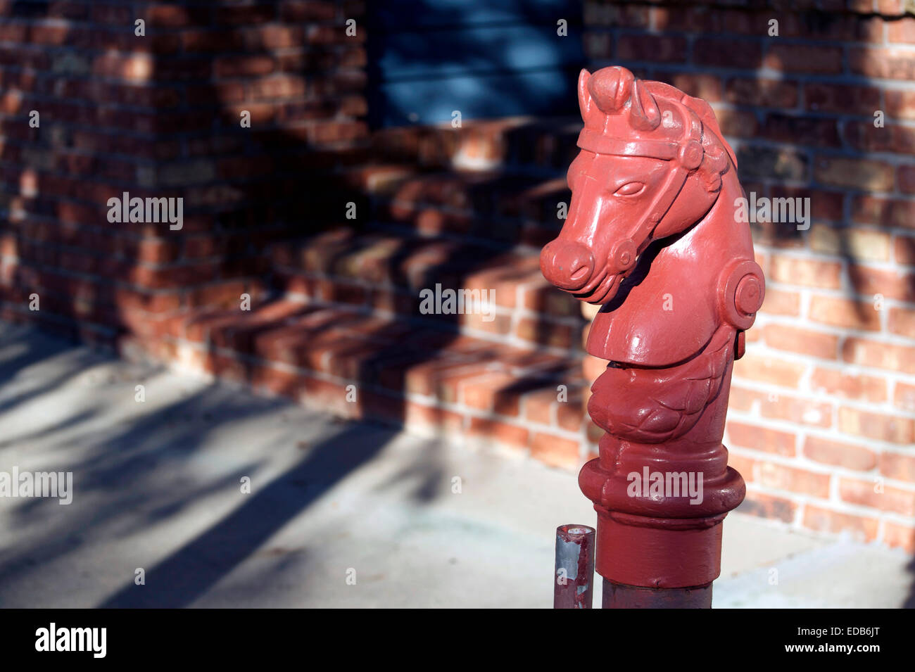 An ornament on a sidewalk, on a pole used for tying a horses reigns Stock Photo