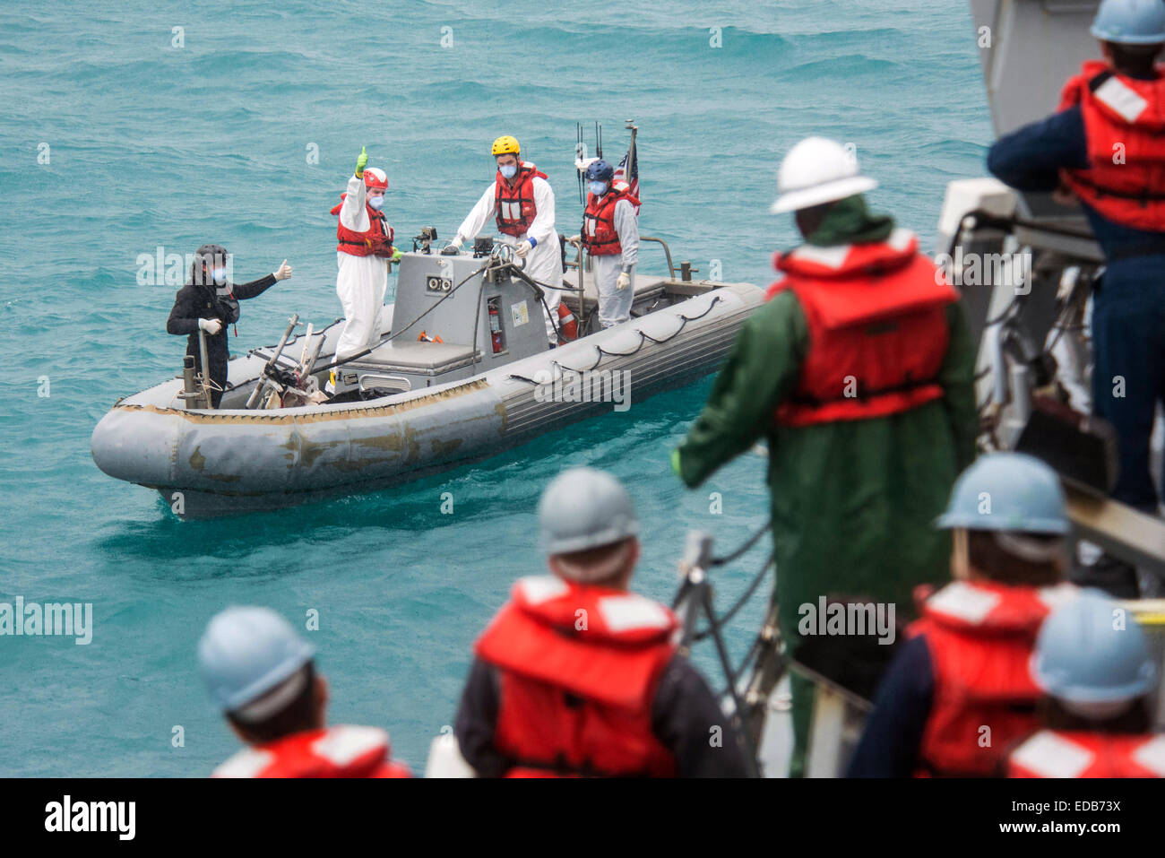 US Navy sailors from the from the Arleigh Burke-class destroyer USS Sampson during search and recovery operations to assist in locating the missing AirAsia Flight QZ 8501 January 4, 2015 in the Java Sea. Stock Photo