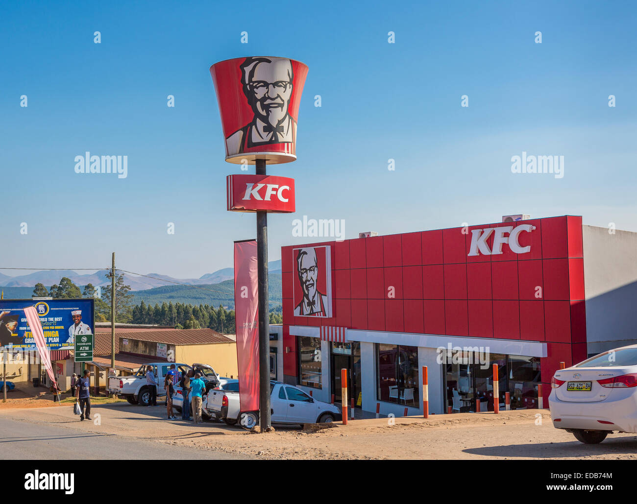 PIGGS PEAK, HHOHHO, SWAZILAND, AFRICA -Kentucky Fried Chicken fast food restaurant and KFC sign, and people on street. Stock Photo