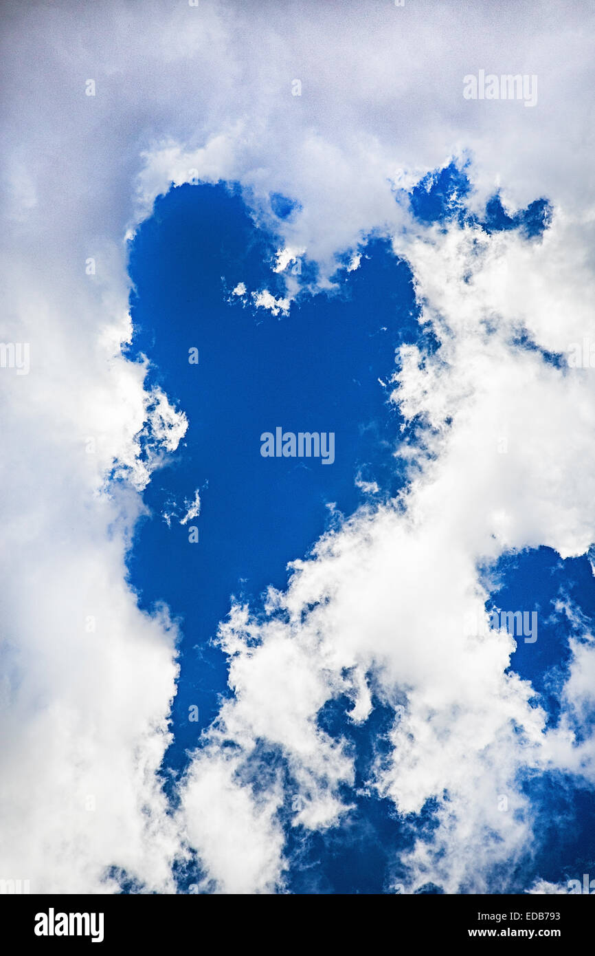 Clouds parting to form a heart-shaped clear blue sky Stock Photo