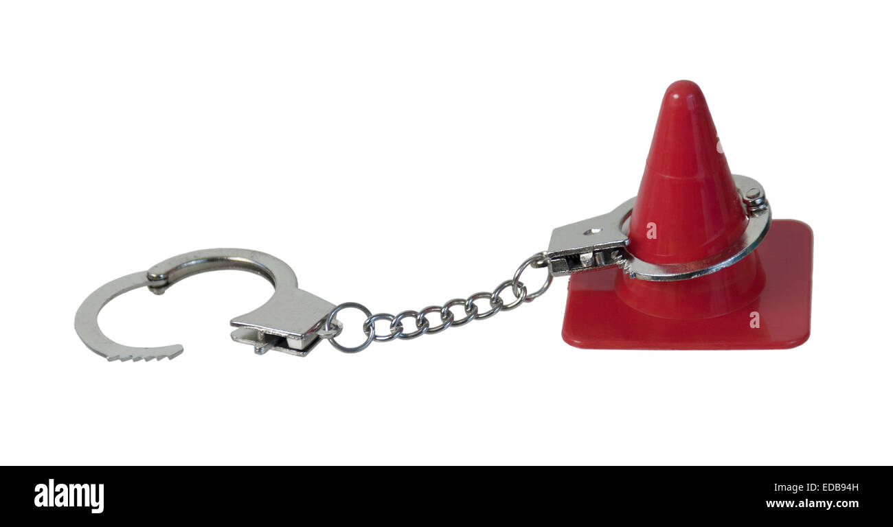 Red Traffic Cone used to direct traffic and handcuffs to designate an infraction - path included Stock Photo