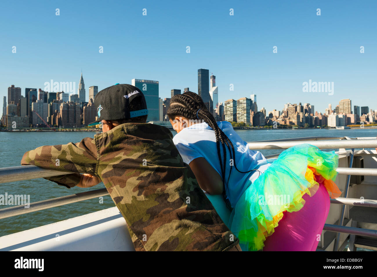 Two children on a ferry, skyline of Manhattan at the back, Manhattan, New York, United States Stock Photo