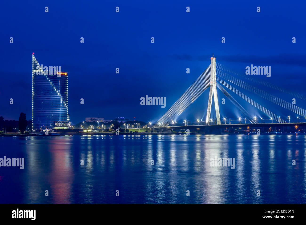 Vanšu Bridge, cable-stayed bridge, dusk, blue hour, over the Daugava river or Western Dvina, with the Swedbank building, Riga Stock Photo