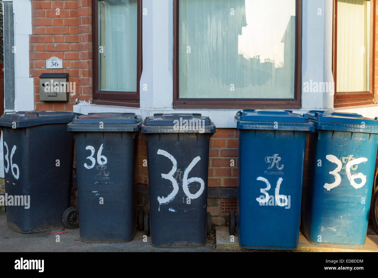 Five wheelie bins with painted numbers at a house of multiple occupancy, i.e. housing divided into many flats, Nottinghamshire, England, UK Stock Photo