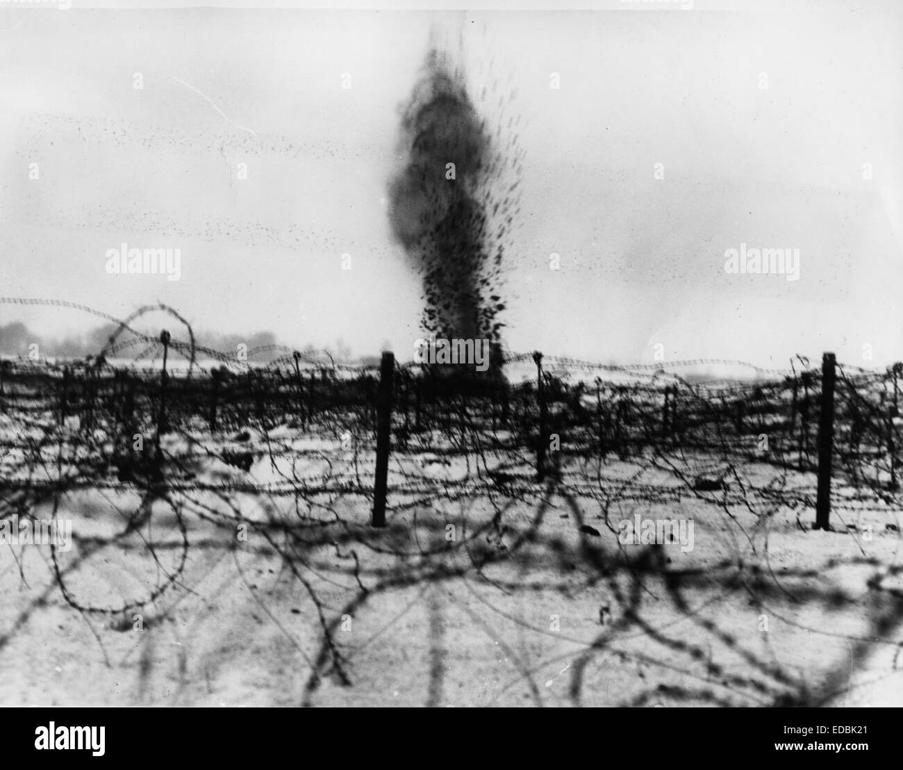 Shell bursting amongst the barbed wire entanglements. Stock Photo