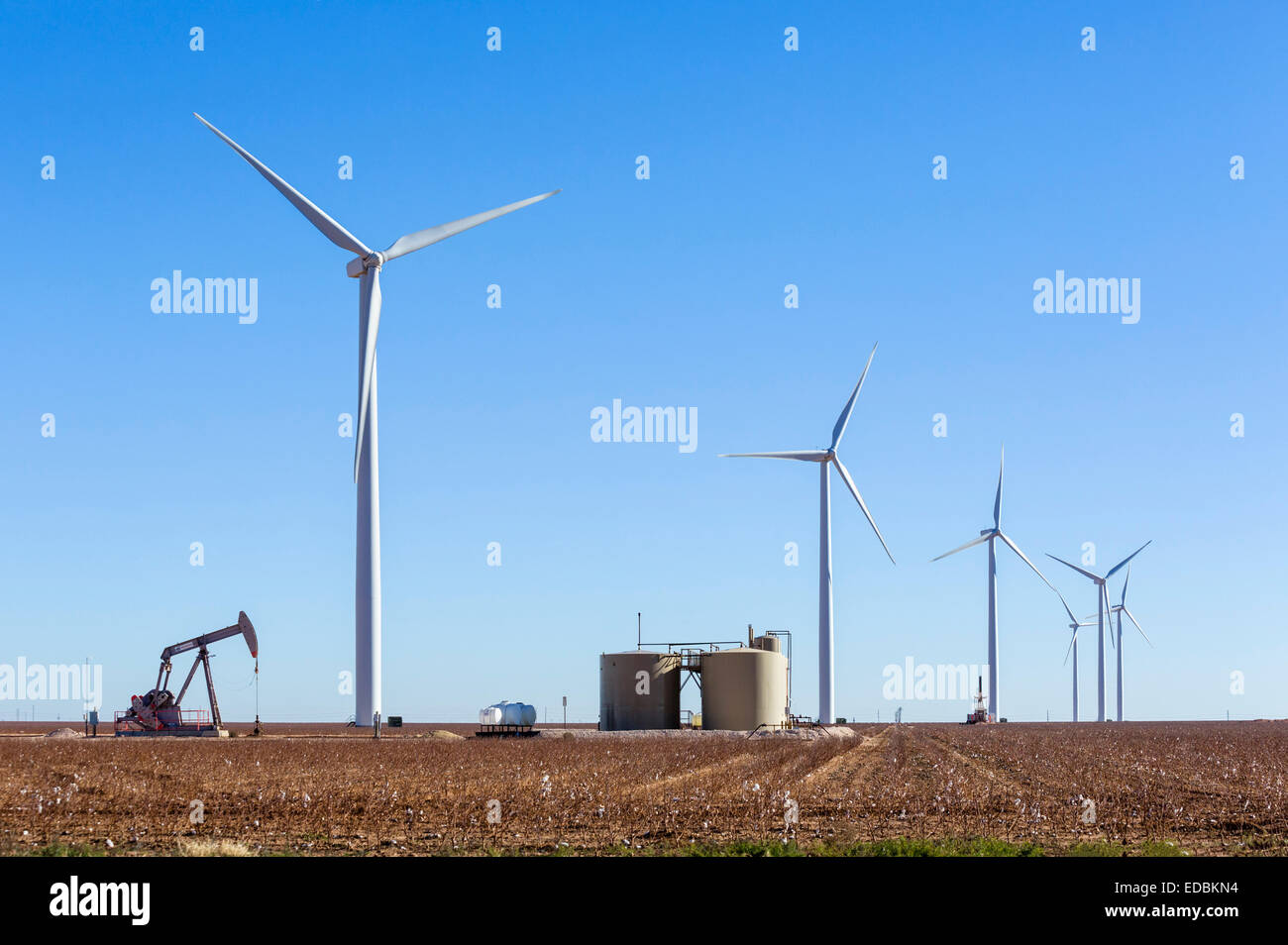 Oil well next to wind turbines outside Midland, Texas, USA Stock Photo