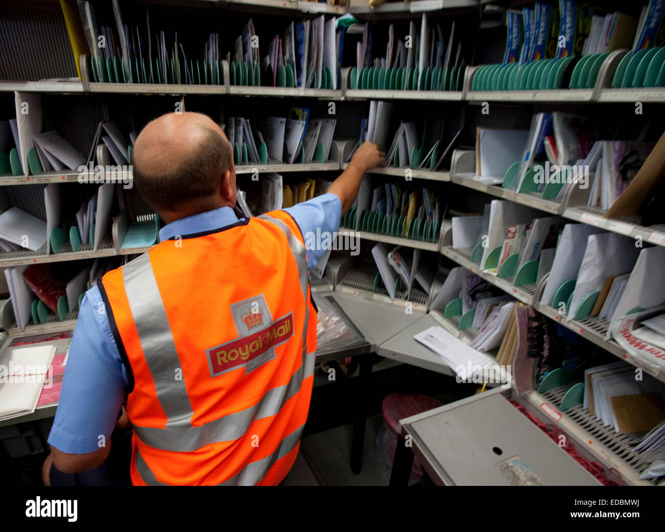 A postal worker sorts letters at a Royal Mail delivery office, Royston. 24/06/2009 Stock Photo