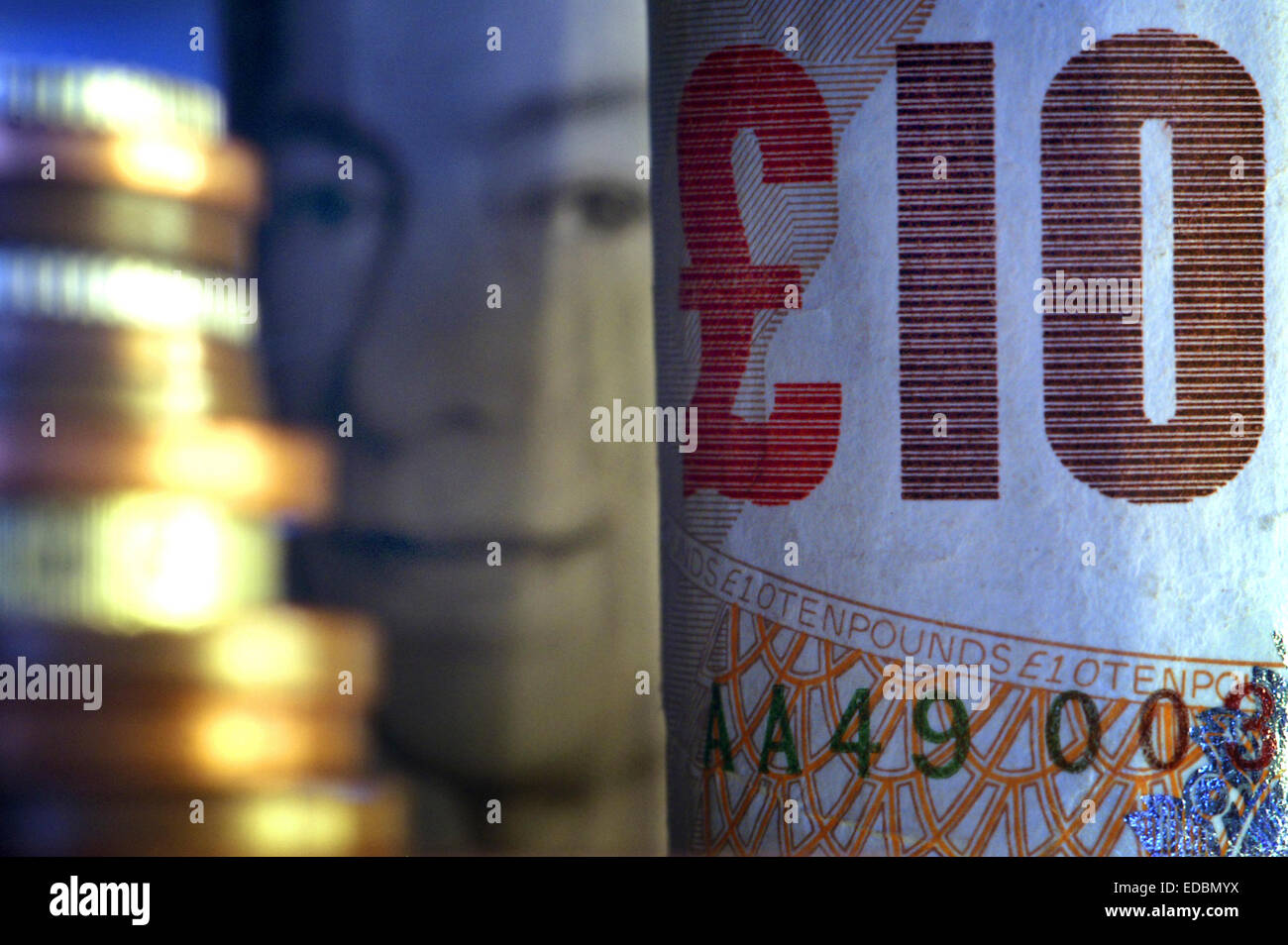 Close-up picture of ten pound notes and a stack of Britsh sterling coins. Stock Photo