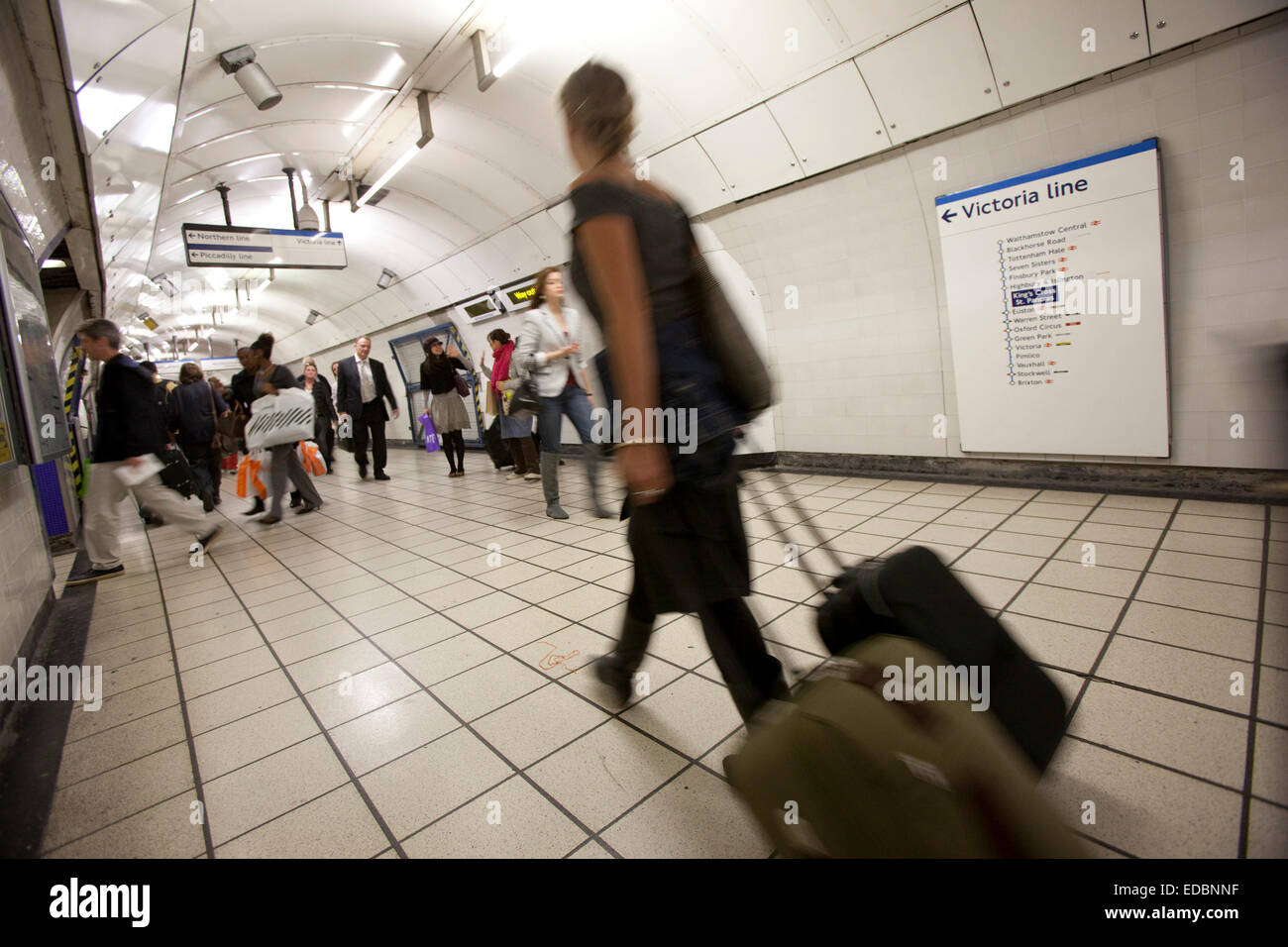 Commuters and tourists make their way to the Victoria line platforms at King's Cross under ground station. Stock Photo