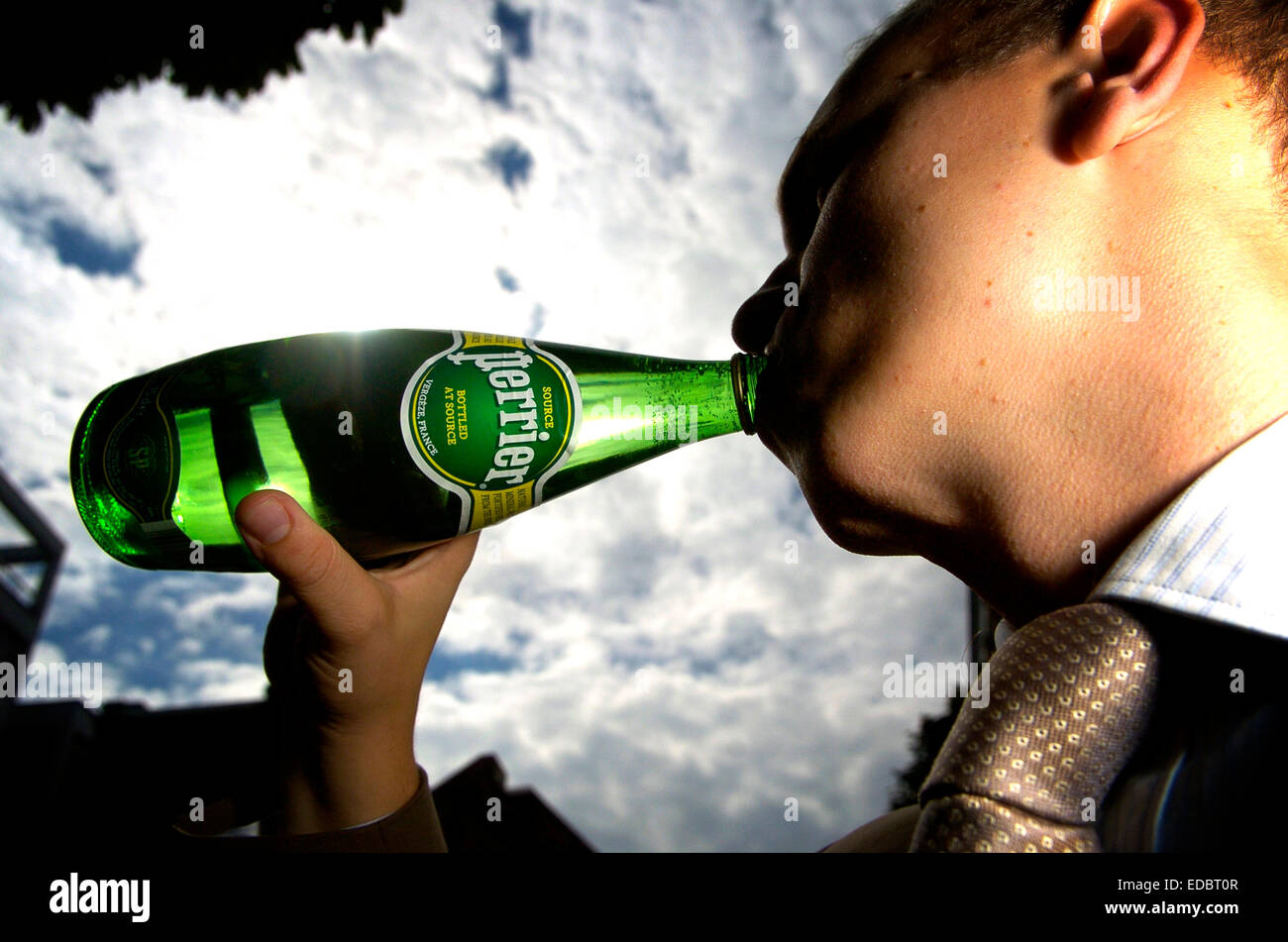 A man drinking Perrier bottled water. Stock Photo
