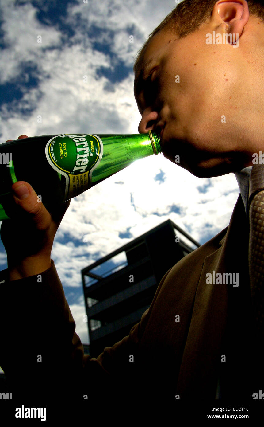 A man drinking Perrier bottled water. Stock Photo