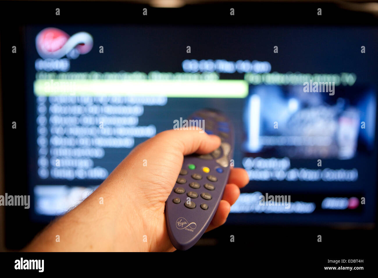 A man browsing the Virgin Media cable television menus and On Demand