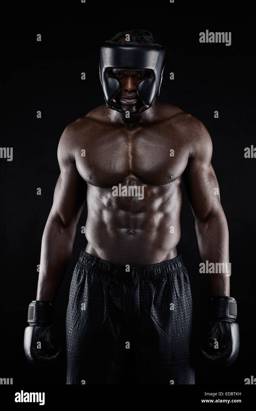 Portrait of African American boxer wearing protective gear standing on
