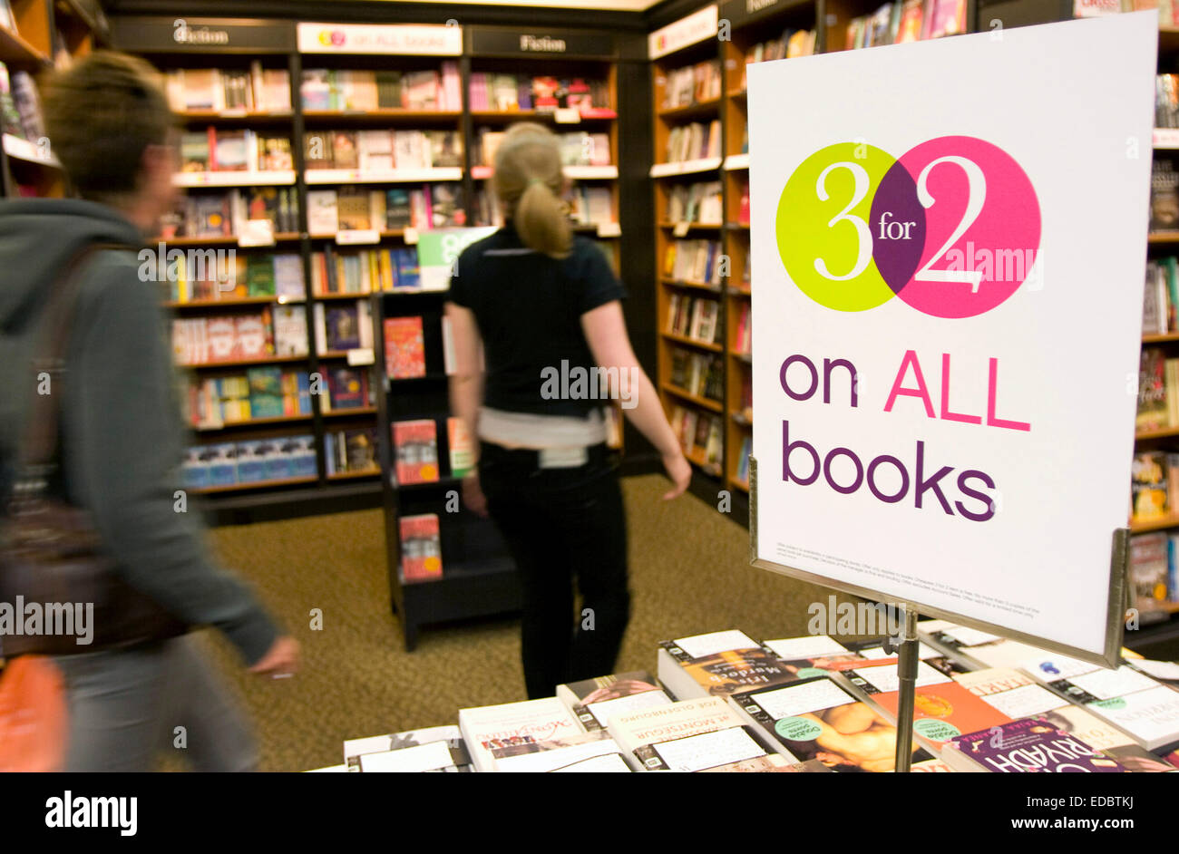 A member of staff guides a customer through a Waterstone's store Stock