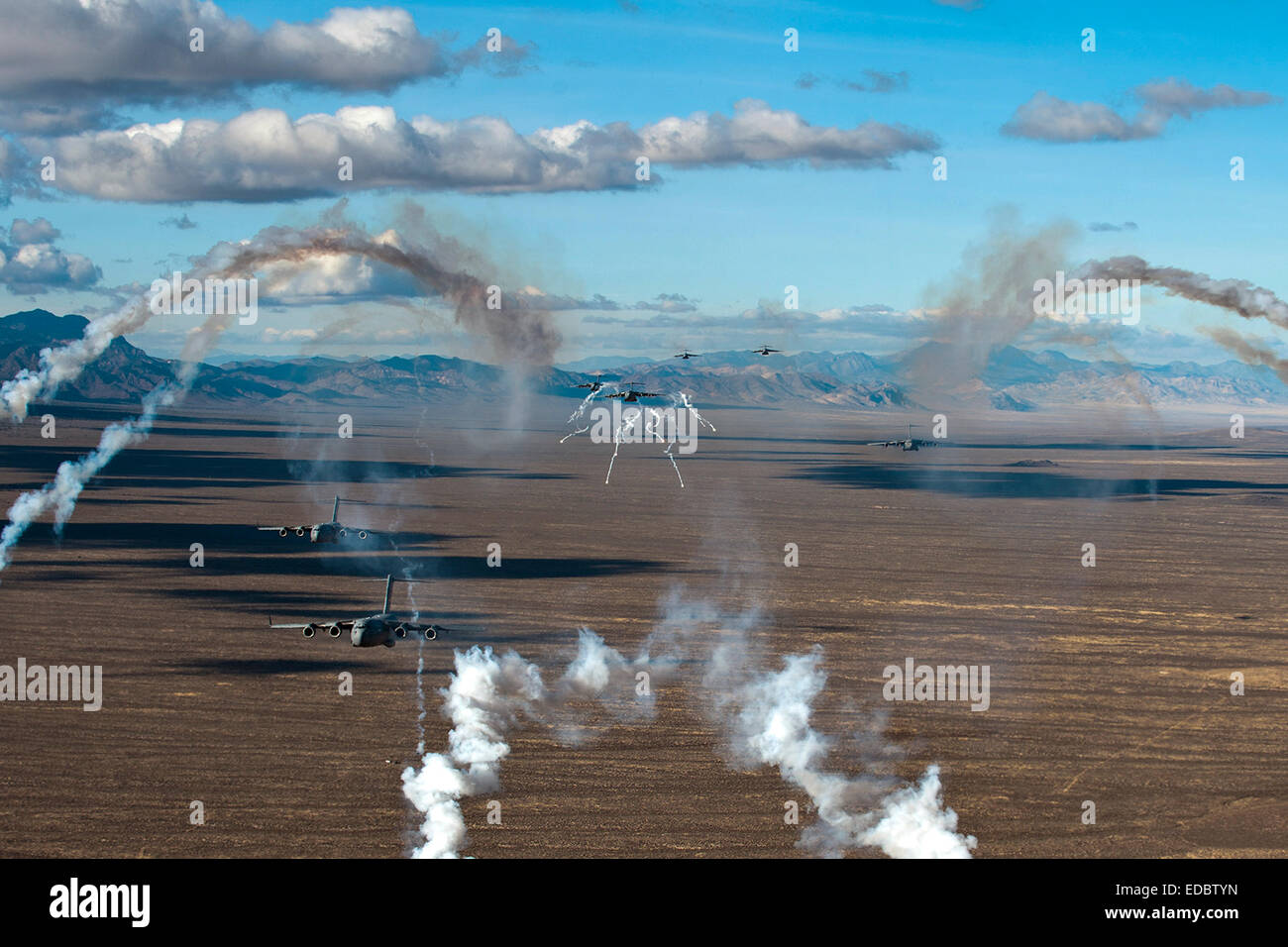 US Air Force C-17 Globemaster III transport aircraft deploy flares in formation while flying in formation over the Nevada Test and Training Range during the Joint Forcible Entry Exercise December 6, 2005 in Nevada. Stock Photo