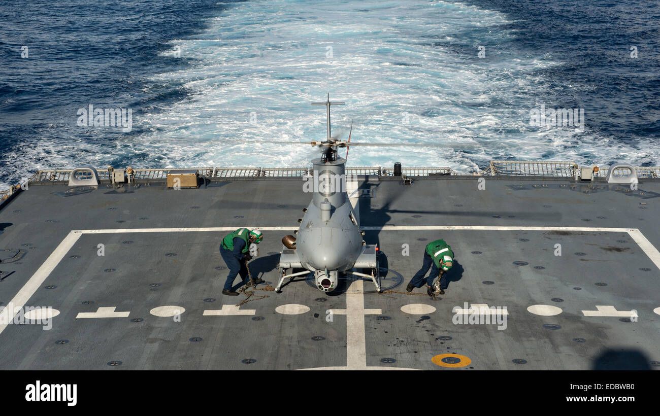 A US Navy sailors secure the MQ-8B Fire Scout unmanned helicopter on the deck of the littoral combat ship USS Fort Worth during flight operations December 17, 2014 in the Pacific Ocean. Stock Photo