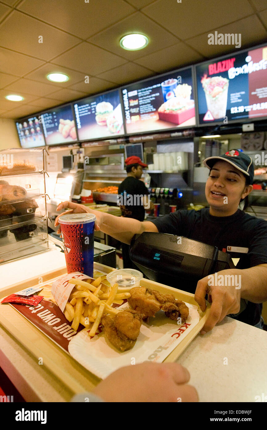A KFC employee serving a hungry customer in the restaurant on Oxford