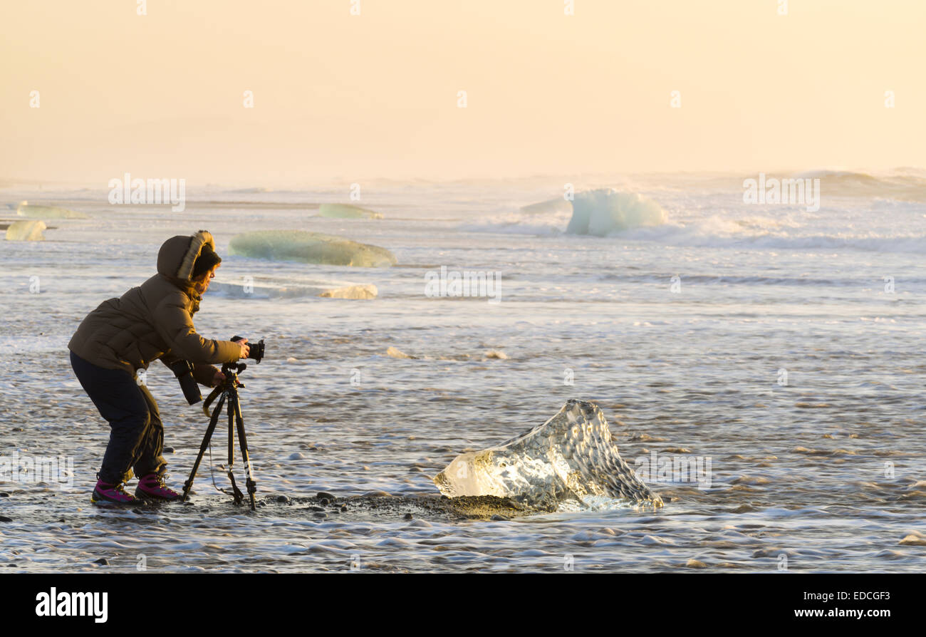 Photographer taking pictures at the Breidamerkurfjara beach, Vatnajokull Ice Cap, Iceland. Stock Photo