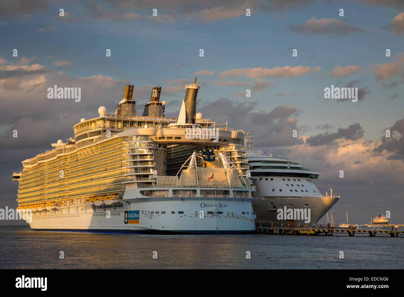Royal Caribbean's gigantic Oasis of the Seas Cruise ship dwarfs a more 'normal' sized ship in port, Cozumel, Yucatan, Mexico Stock Photo
