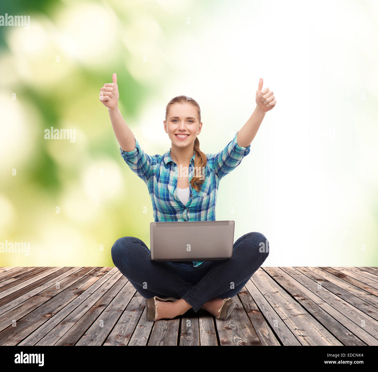 smiling woman with laptop and showing thumbs up Stock Photo - Alamy