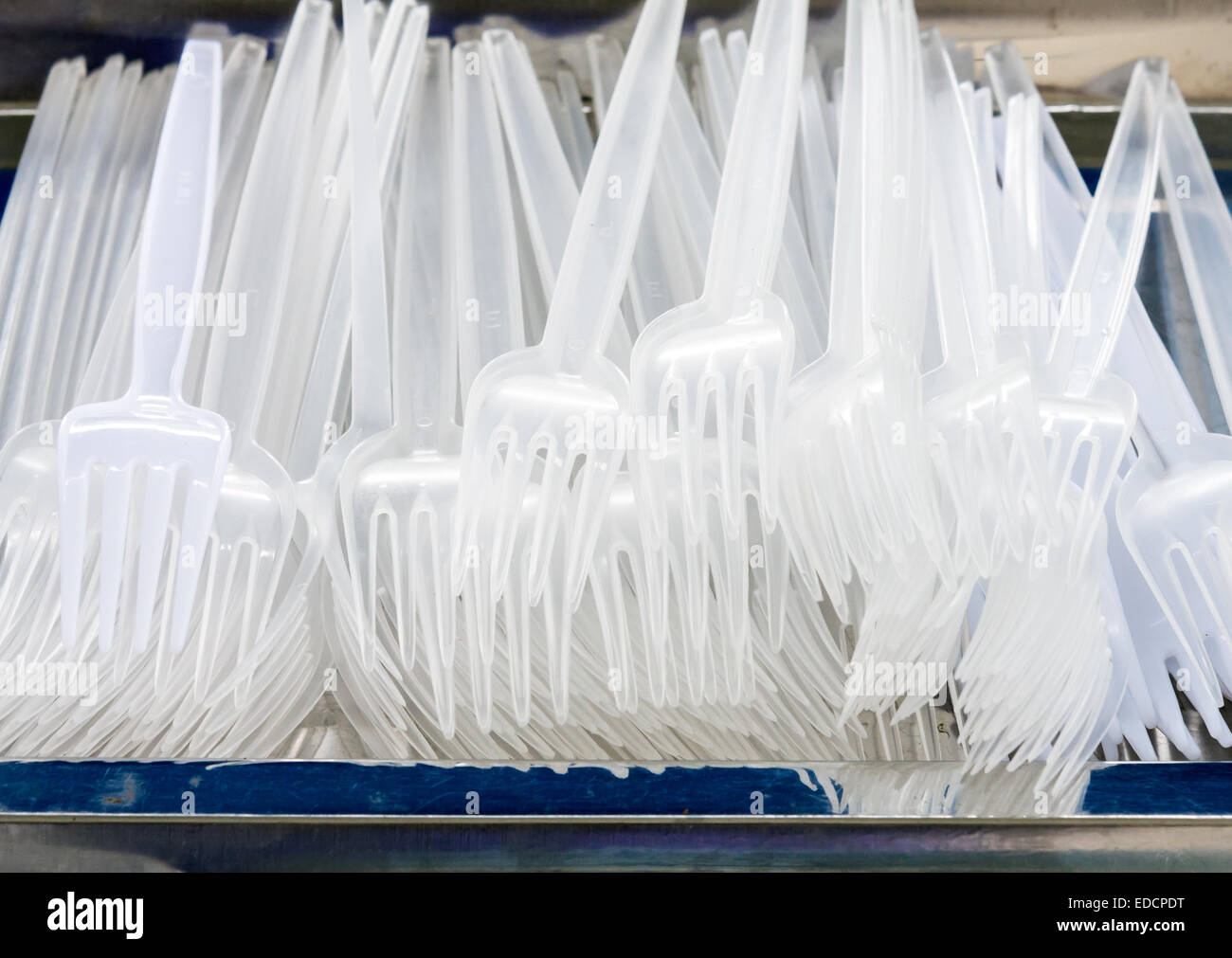 White plastic fork on the metal tray. Stock Photo