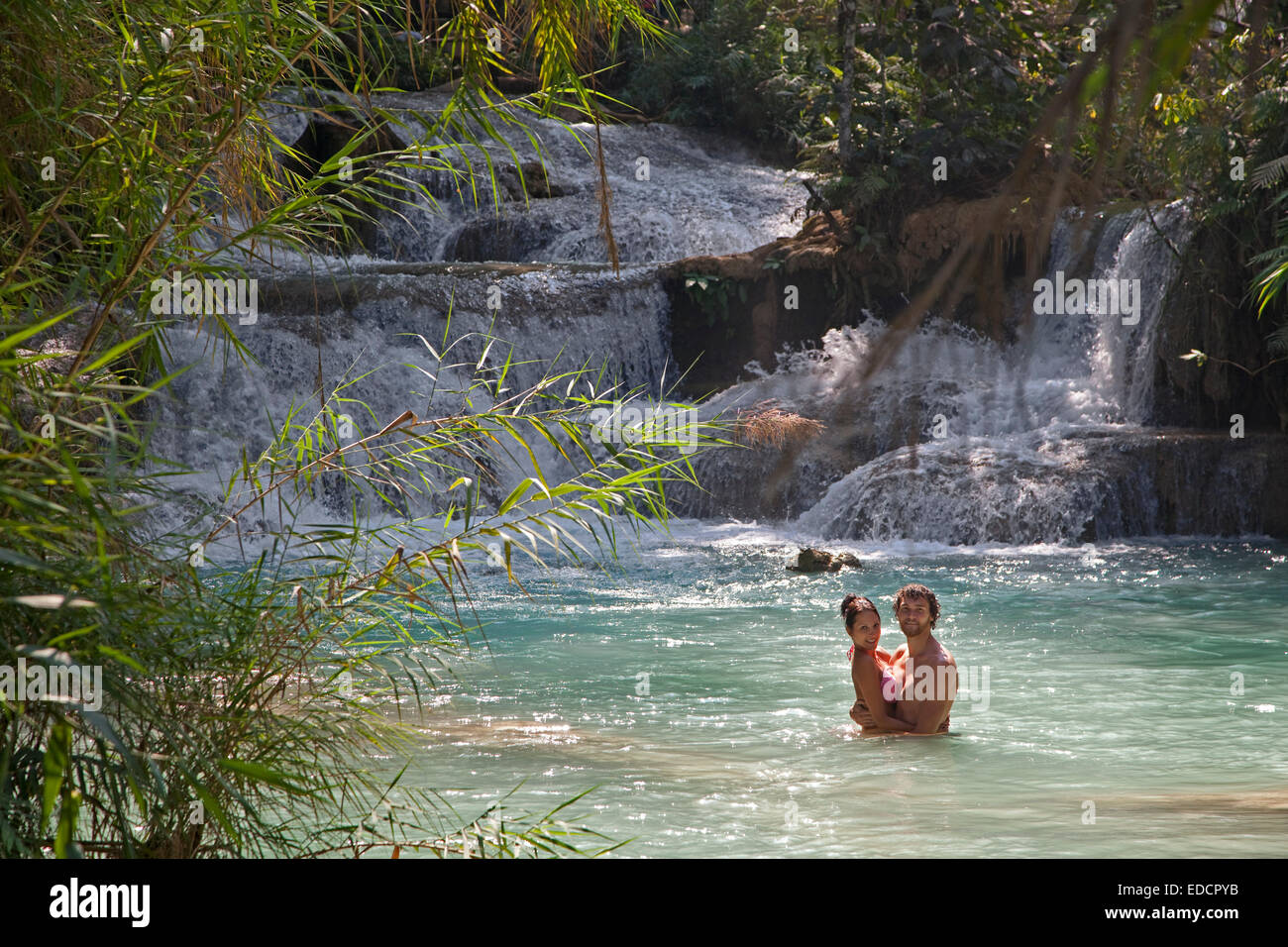 Romantic couple in turquoise blue pool of the Kuang Si Falls / Kuang Xi / Tat Kuang Si Waterfalls near Luang Prabang, Laos Stock Photo