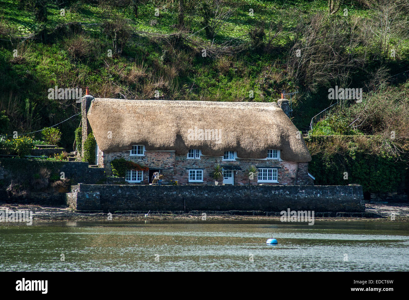Thatched House on river dart viewed from a boat on the river dart Stock